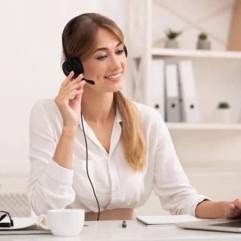 Asesora con auriculares atendiendo una consulta frente a una notebook